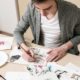 a man focused on his art at a table, learning how to become a freelance artist
