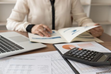 businesswoman analyzing financial documents while using Xero online bookkeeping software for efficient management