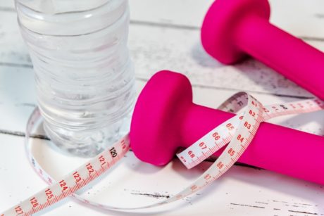 pink dumbbells and measuring tape