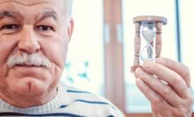 old man holding small hourglass