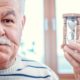 old man holding small hourglass