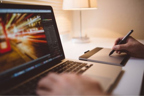 person using photoshop in laptop