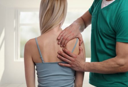 therapist performing acupressure on female patient