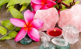 a serene beach scene featuring roses, crystals, and a candle, symbolizing the calming essence of introduction to crystal healing