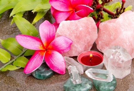 a serene beach scene featuring roses, crystals, and a candle, symbolizing the calming essence of introduction to crystal healing