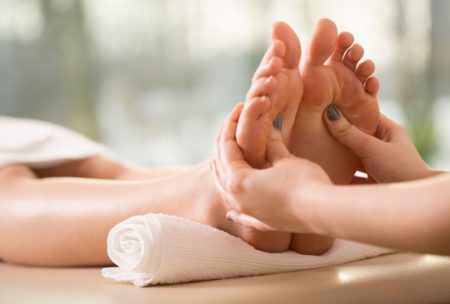 individual receiving a soothing foot massage in a tranquil spa, emphasizing the relaxation offered by reflexology courses online