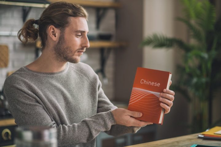 man holding chinese language book