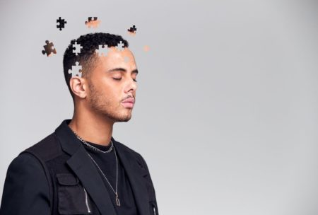 man with jigsaw puzzle pieces on head
