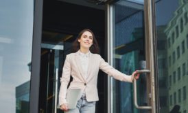 confident woman walking out glass door