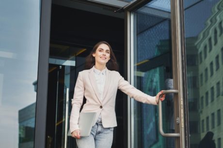 confident woman walking out glass door