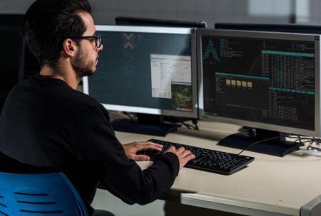 man typing on desktop computer