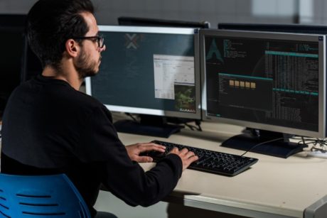 man typing on desktop computer