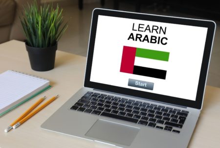 Arabic For Beginners. A digital image showing a laptop with a language learning website open, displaying Arabic text and lessons.