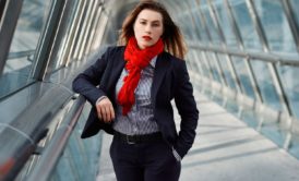 A professional woman wearing a business suit and red scarf, demonstrating body language fundamentals