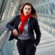 A professional woman wearing a business suit and red scarf, demonstrating body language fundamentals