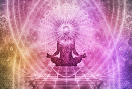 a woman in a lotus position with arms outstretched, embodying peace during a chakra healing course