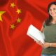 A woman holding a book in front of a Chinese flag, promoting 'earn Chinese For Beginners