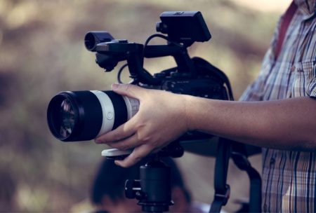 a participant in a cinematography masterclass holds a camera, focused on capturing the perfect shot