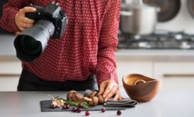 a woman captures a beautifully arranged dish with her camera during a food photography course
