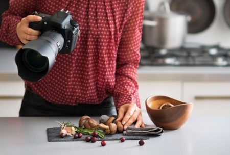 a woman captures a beautifully arranged dish with her camera during a food photography course