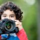 young boy with a camera, learning about photography for kids by taking a picture