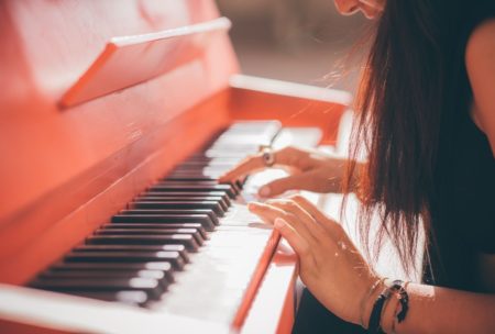 a woman skillfully playing the piano, piano course online for aspiring musicians