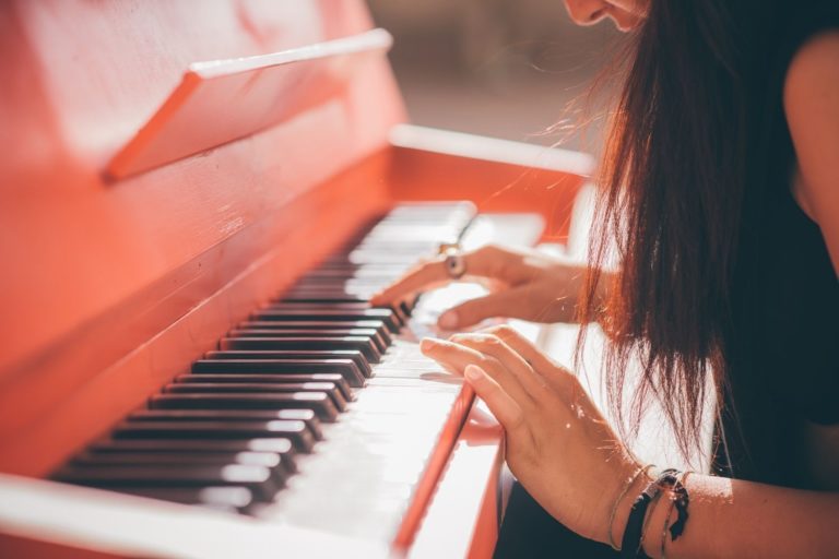 a woman skillfully playing the piano, piano course online for aspiring musicians
