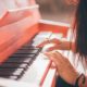 a woman skillfully playing the piano, piano course online for aspiring musicians