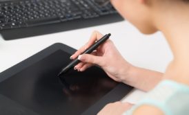 A woman creating digital paintings on a tablet computer using a pen