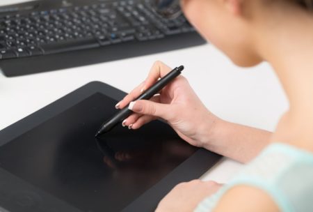 A woman creating digital paintings on a tablet computer using a pen