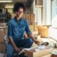 a woman in a warehouse surrounded by boxes, working on a laptop for her eBay dropshipping business