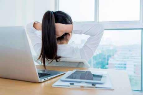 a woman at a desk, head in hands, reflecting on her journey in an emotional resilience course