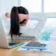 a woman at a desk, head in hands, reflecting on her journey in an emotional resilience course