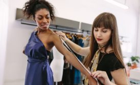 A woman who wants to become a celebrity fashion stylist holds a tape measure.