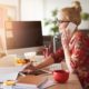 a woman seated at a desk, engaged in a phone conversation, embodying the essence of Fiverr secrets in her work