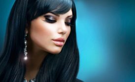 Elegant woman with long black hair and earrings, showcasing her stylish hair and make up