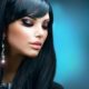 Elegant woman with long black hair and earrings, showcasing her stylish hair and make up