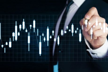 Man in a suit guiding beginners in investing in stocks for beginners, pointing at an upward trend chart