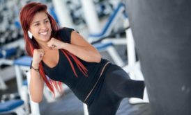 A person practicing kickboxing for fitness, throwing a powerful punch in a gym setting