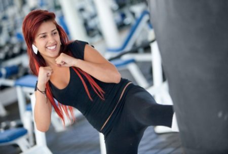 A person practicing kickboxing for fitness, throwing a powerful punch in a gym setting