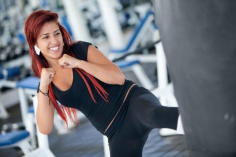 A person practicing kickboxing for fitness, throwing a powerful punch in a gym setting