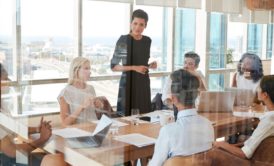 A woman confidently presents to a group, showcasing her leadership skills mastery