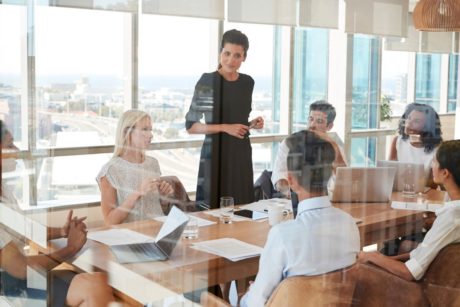 A woman confidently presents to a group, showcasing her leadership skills mastery