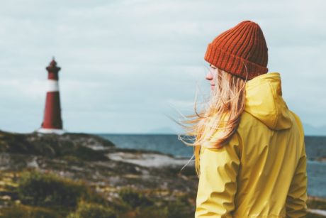 woman in yellow jacket norwegian landscape