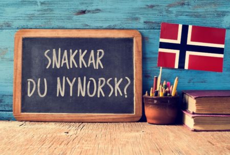 norwegian flag and greeting written on blackboard