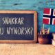 norwegian flag and greeting written on blackboard