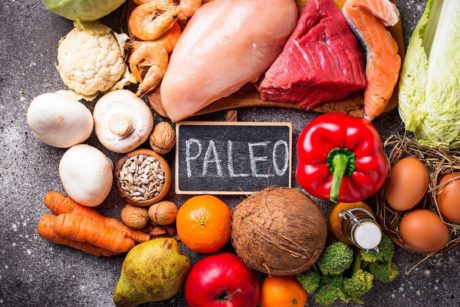 The word 'paleo' surrounded by a variety of nutritious foods for paleo meal prep