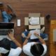 two people on the floor with laptops and boxes, collaborating on an Amazon FBA product launch strategy