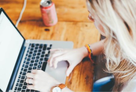 woman typing on silver laptop