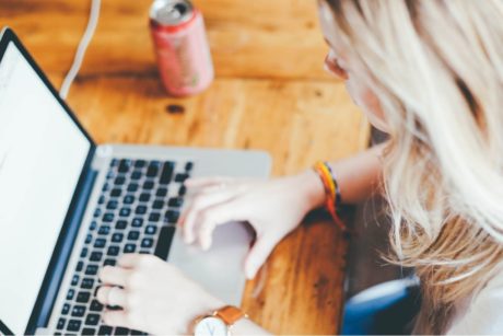 woman typing on silver laptop